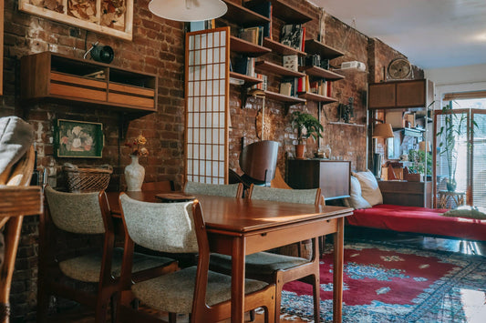 Aesthetic living room showcasing a brick wall and table, complemented by art decor for an elegant touch.