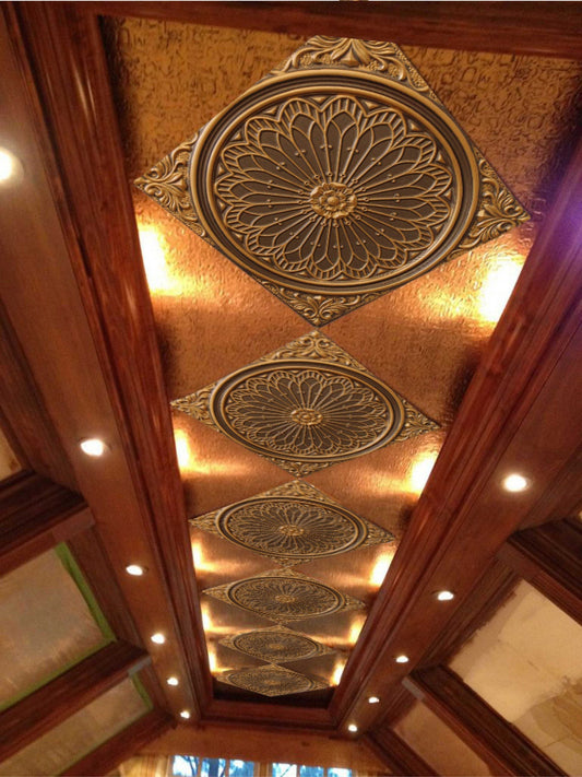 Decorative ceiling tile with intricate designs and lights.