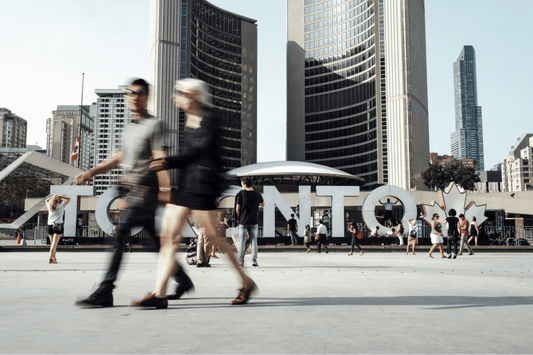 people walking around the toronto sign