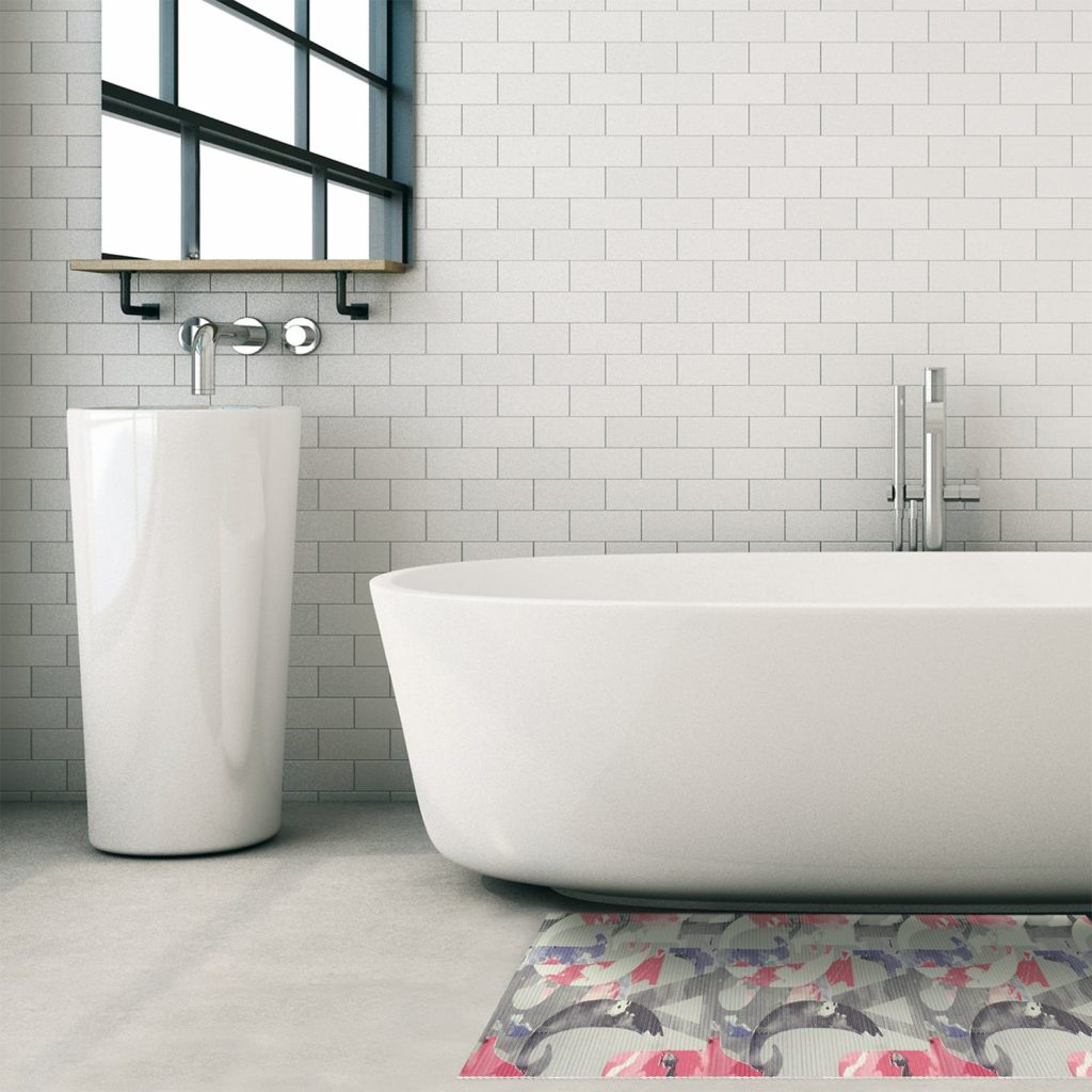 White bathtub and sink with pink and grey bathtub floor mat